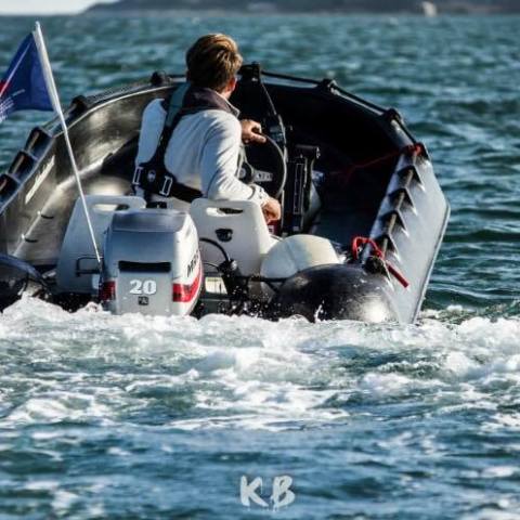 a man riding on the back of a boat in the water