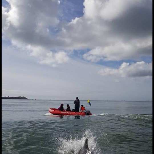 a man riding on the back of a boat in a body of water